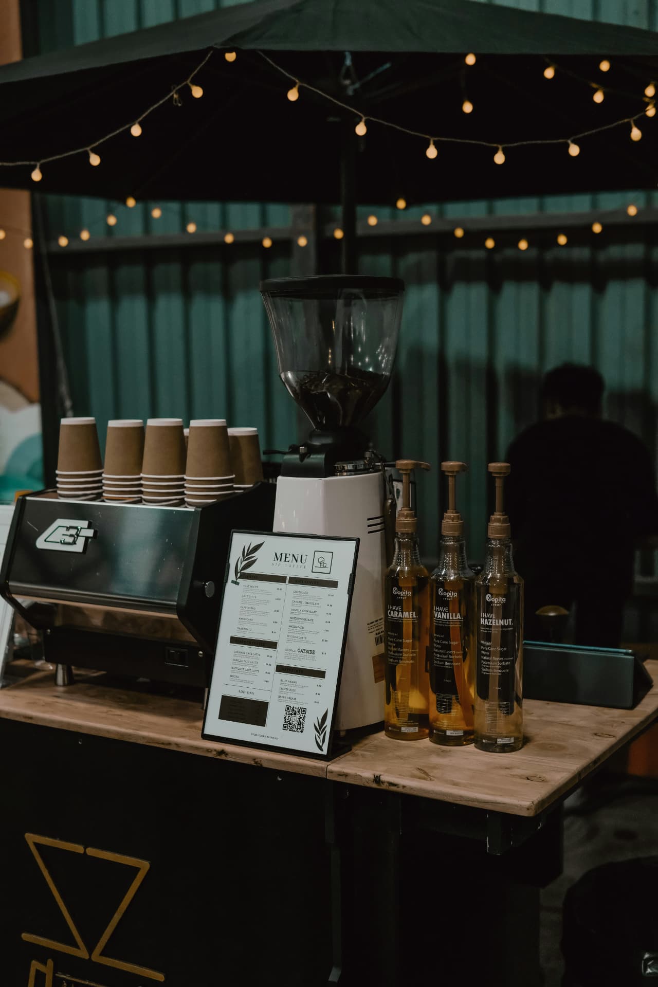 Professional espresso bar setup with grinder, syrups, and menu for a corporate event