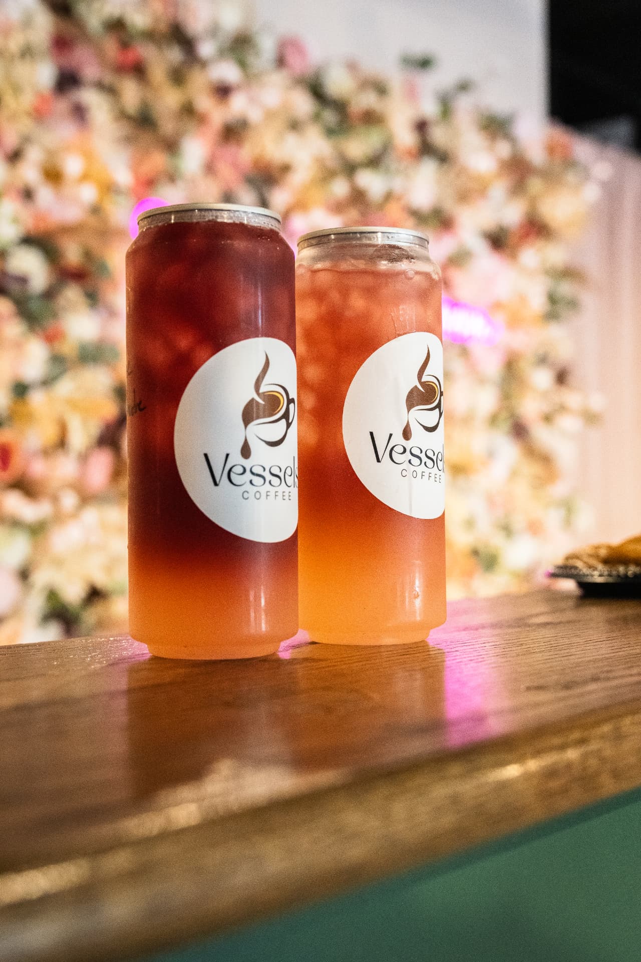 Two Vessels Coffee branded iced refreshers on a wooden bar